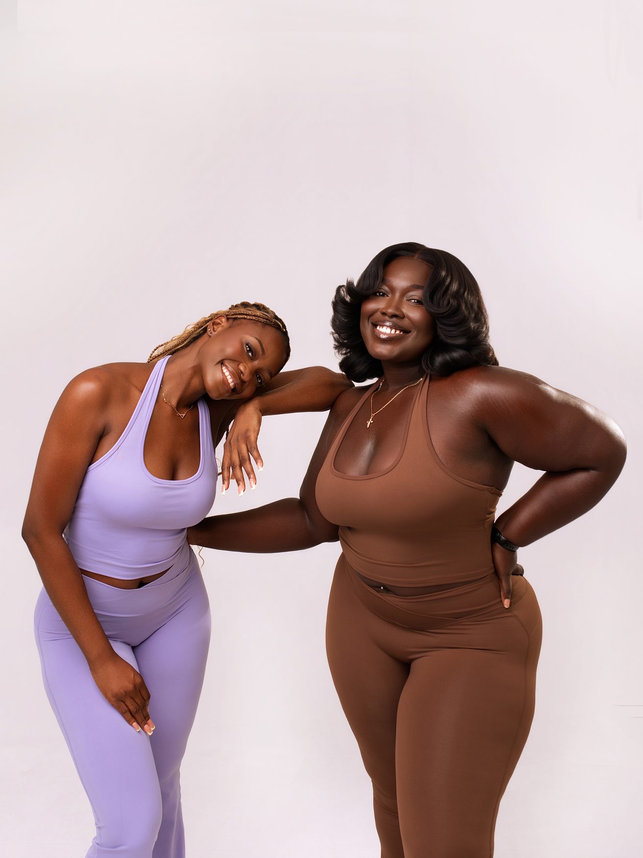 Two FYNE Motion women in the Lilac and Cocoa sets